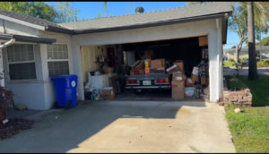 Garage with belongings and a car left behind at a Riverside County house sold as-is